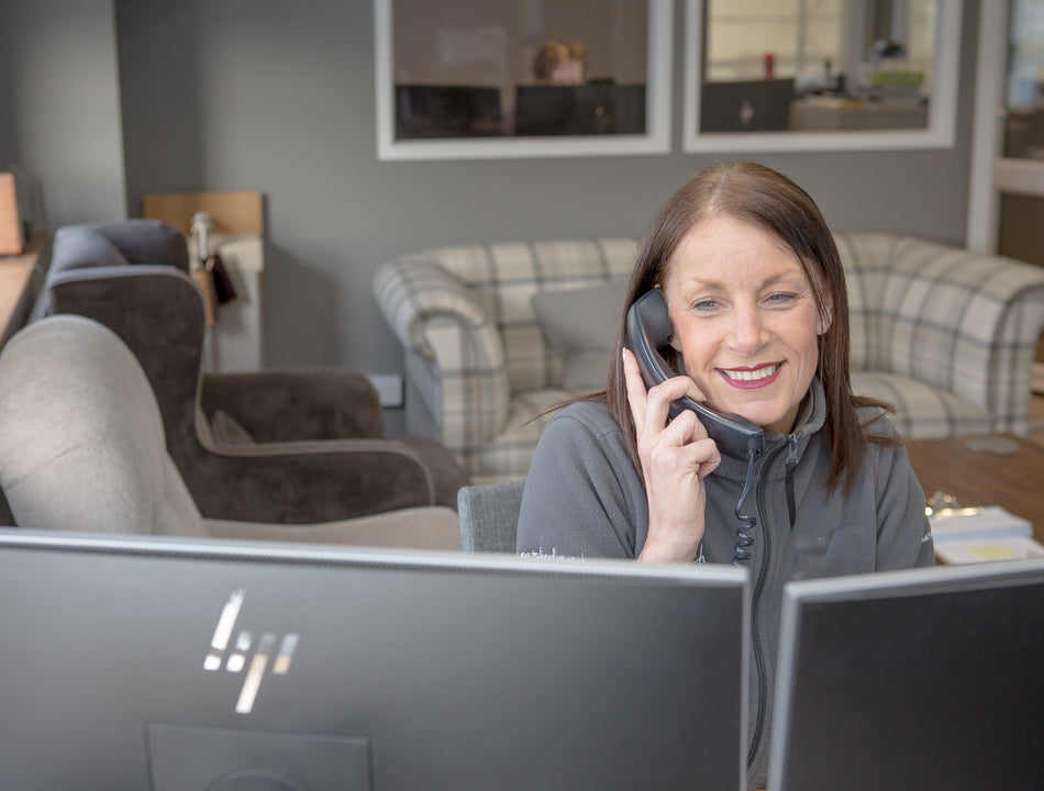 A worker on the phone in front of 2 computers