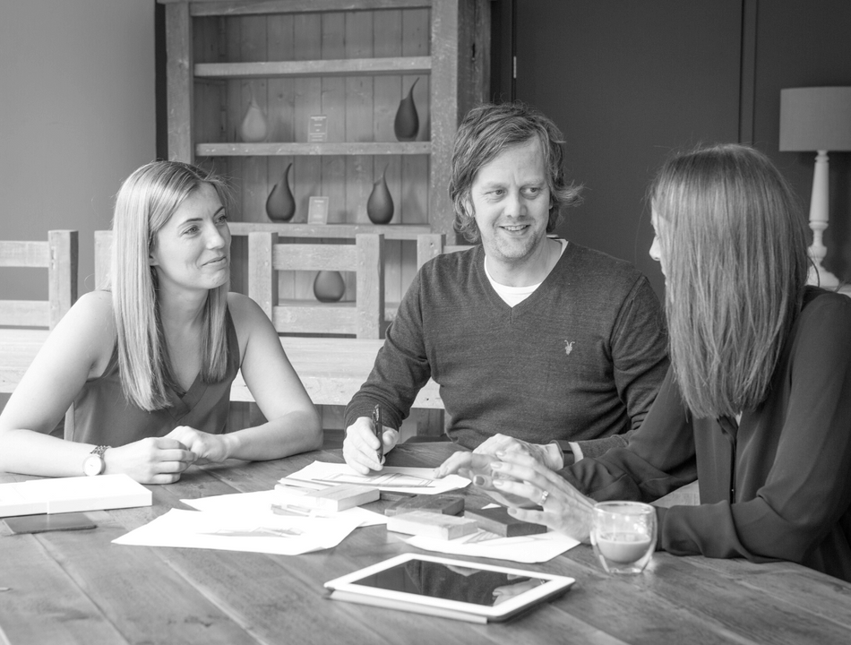 Staff of Eat, Sleep, Live having a meeting round a table
